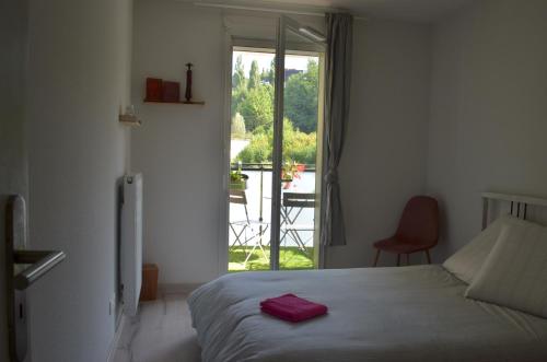 a bedroom with a bed and a view of a balcony at Aiko&Moi in Annecy