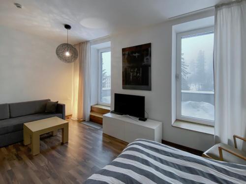 a living room with a couch and a tv in it at No.1 Apartment House Oliver in Štrbské Pleso