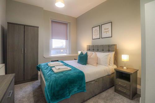 a bedroom with a large bed and a window at Townend Apartment in Dumbarton