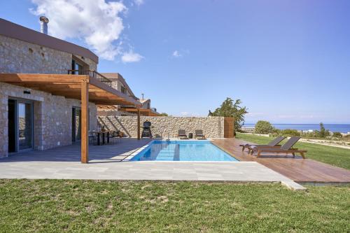 a villa with a swimming pool next to a building at Anar Villas Rhodes in Koskinou