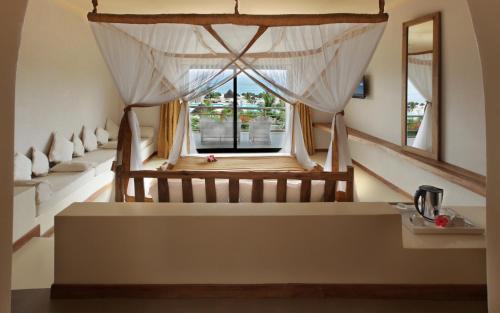 a room with a window with curtains and a table at Gold Zanzibar Beach House & Spa in Kendwa