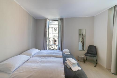 ein Schlafzimmer mit einem Bett, einem Stuhl und einem Fenster in der Unterkunft Osteria Pozzo in Locarno