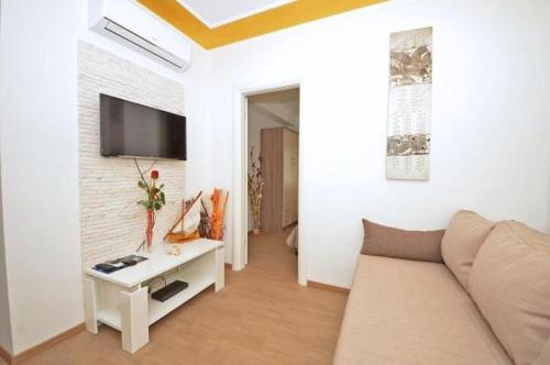 ein Wohnzimmer mit einem Sofa und einem TV an der Wand in der Unterkunft Guest House Mia in Split