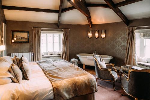 a bedroom with a large bed and a tub in it at The Royal Hotel in Kirkby Lonsdale