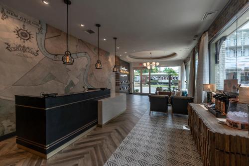 a restaurant with a counter and a bar at St Charles Coach House, an Ascend Collection Hotel in New Orleans