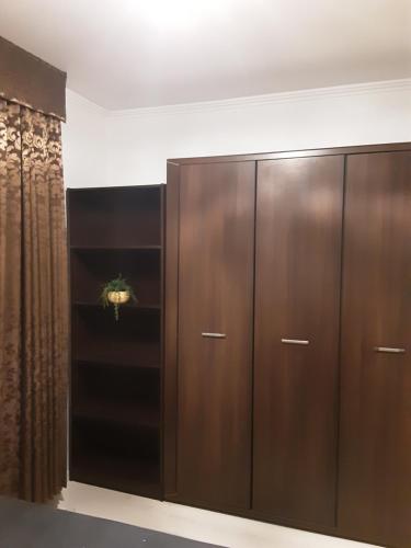a large wooden wardrobe in a room with a curtain at MELÁNIA in Vonyarcvashegy