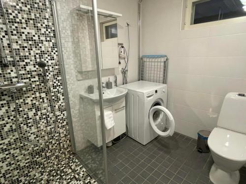 a bathroom with a toilet and a sink and a shower at Rauhan Marinella Apartments in Imatra
