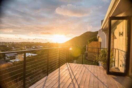 a balcony of a house with the sun setting at Ridge House in Hermanus
