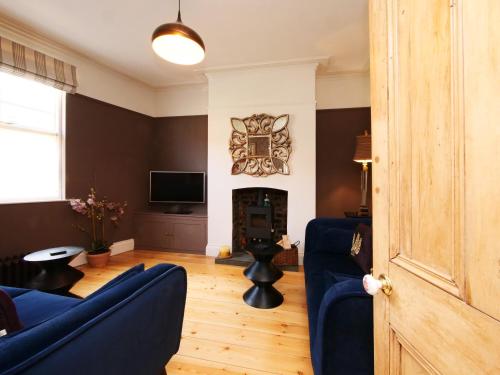 a living room with blue couches and a tv at Courtyard Cottage York - Free Parking in York
