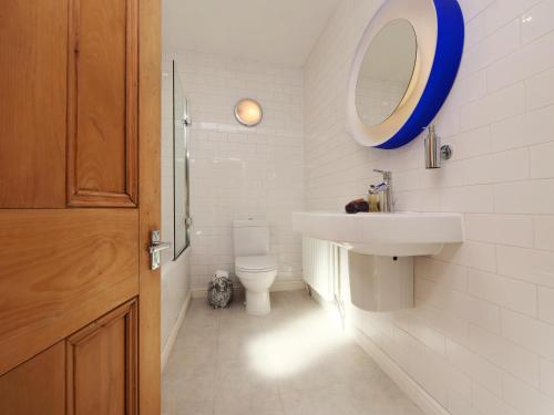 a bathroom with a sink and a mirror and a toilet at Courtyard Cottage York - Free Parking in York