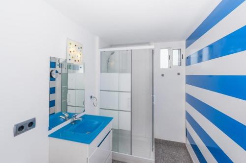 y baño con lavabo azul y ducha. en Villa Sa Marina, en Alcudia