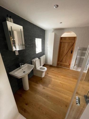 a bathroom with a sink and a toilet and a door at Common Farmhouse in Newark-on-Trent