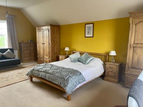 a bedroom with a bed and a yellow wall at Common Farmhouse in Newark-on-Trent