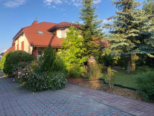 a house with a brick walkway in front of a yard at Domowe Zalesie in Piaseczno