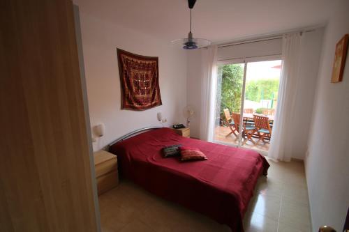 ミアミ・プラトーヤにあるCasa Chiquiのベッドルーム(赤いベッド1台、バルコニー付)