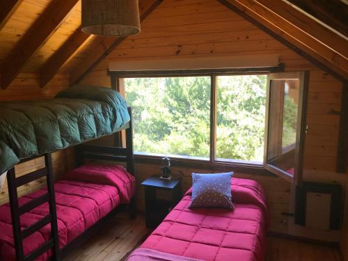 2 łóżka piętrowe w kabinie z oknem w obiekcie Alojamiento Ruca Wenüy dpto 03 w mieście Bariloche