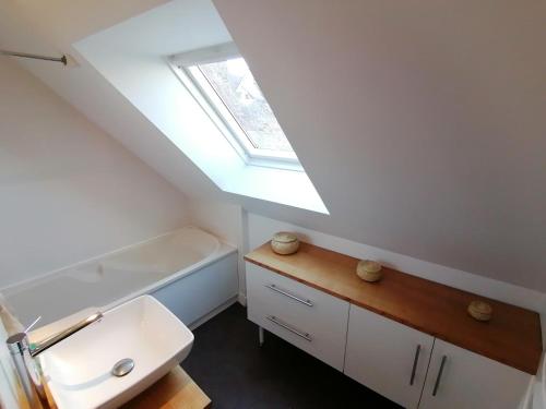 a bathroom with a white sink and a skylight at OFFRE DE LANCEMENT, IDEAL GROUPE, BILLARD in Mauriac