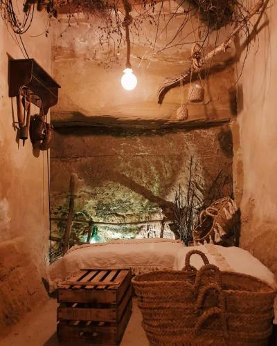 a bedroom with a bed and a basket in a cave at Hospedería Señorío de Briñas in Briñas