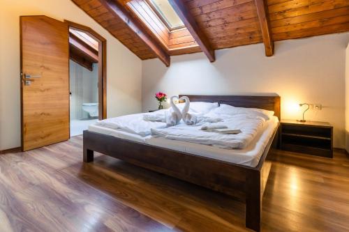 a bedroom with a large bed with white sheets at Villa Gardenia in Donovaly