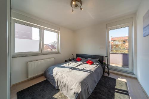 een slaapkamer met een bed en 2 ramen bij SUPER PetrovA Apartment in Zagreb