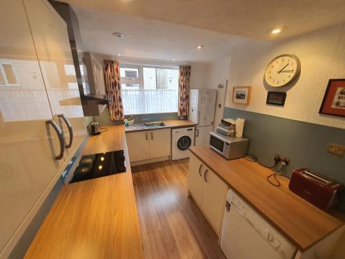 a kitchen with a counter and a clock on the wall at Eilean View in Lamlash