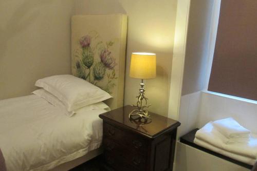 a bedroom with a bed and a table with a lamp at Old Town 163 in Edinburgh