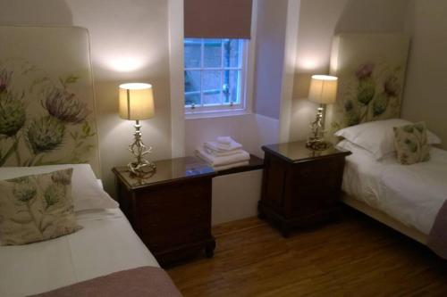 a room with two beds and two lamps and a window at Old Town 163 in Edinburgh