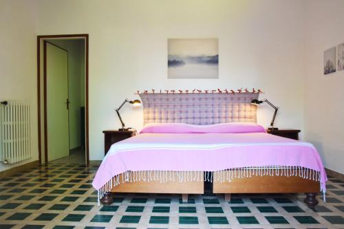 a bedroom with a bed with a pink bedspread and two lamps at Villa il Forte in Forte dei Marmi