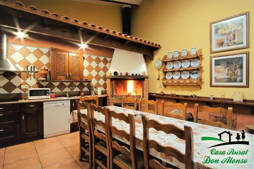 cocina con mesa, sillas y chimenea en Casa Rural Don Alonso, en Villalgordo del Júcar