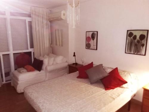 ein Schlafzimmer mit einem weißen Bett und einer Couch in der Unterkunft La Brisa Malagueta in Málaga