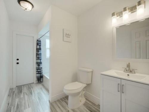 Baño blanco con aseo y lavamanos en Modern Bayshore Home 46 en Tampa