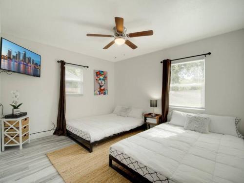 a bedroom with two beds and a ceiling fan at Modern Bayshore Home 46 in Tampa