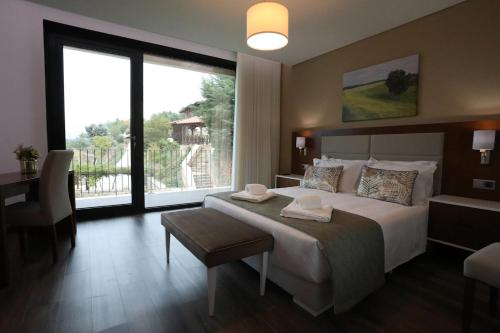 a hotel room with a large bed and a large window at O Casario in Mirandela