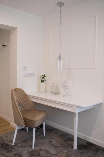 a white desk with a chair in a room at Mały Sopot Boutique in Iława