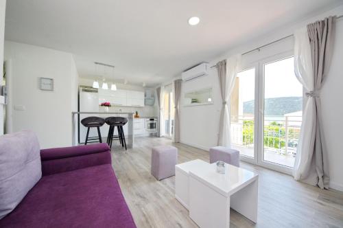 ein Wohnzimmer mit einem lila Sofa und einem Tisch in der Unterkunft Apartmani Maris in Poljica