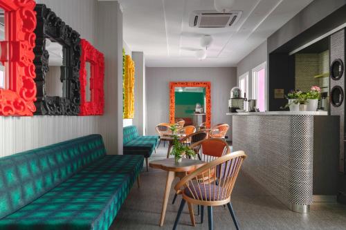 a restaurant with a green couch and a table and chairs at Hotel Rainbow ***S in Rimini