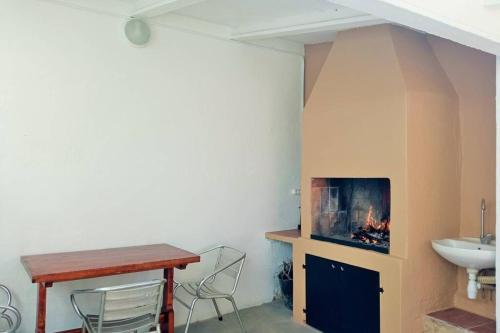 een kamer met een open haard, een tafel en een wastafel bij Villa Valentina in Girona