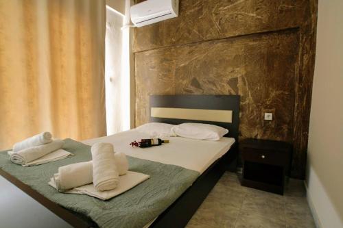 1 dormitorio con 1 cama con toallas en LDG Rooms, en Olympiakí Aktí