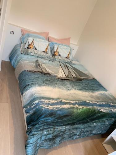 a bedroom with a painting of boats on a bed at Pluk de dag in Oostduinkerke