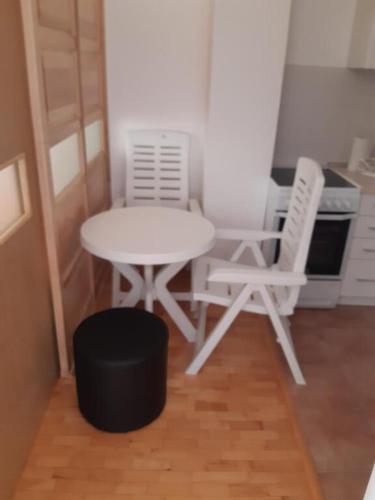 a small kitchen with a table and two chairs at Apartman FAMILY in Foča