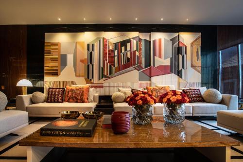a living room with couches and a table with flowers at Vinha Boutique Hotel - The Leading Hotels of the World in Vila Nova de Gaia