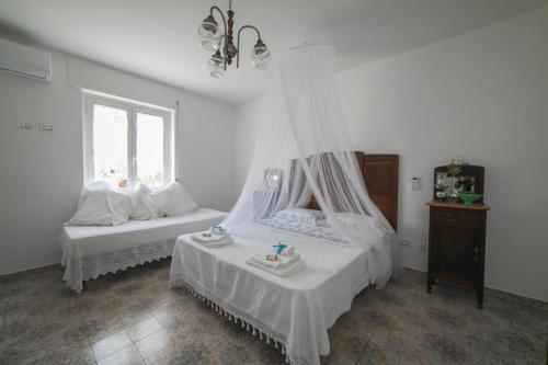 een slaapkamer met 2 bedden en een raam bij Reginella al mare in Policastro Bussentino