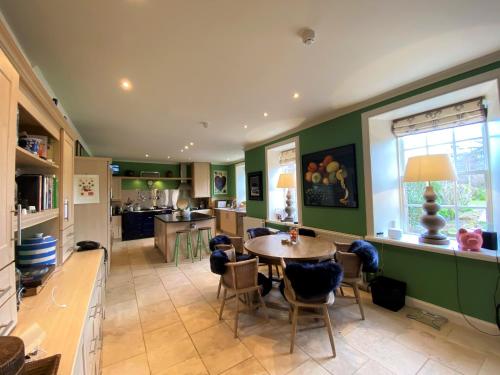 a kitchen with a table and chairs in a room at Carnell Country Estate & Holiday Cottages in Ayrshire in Hurlford