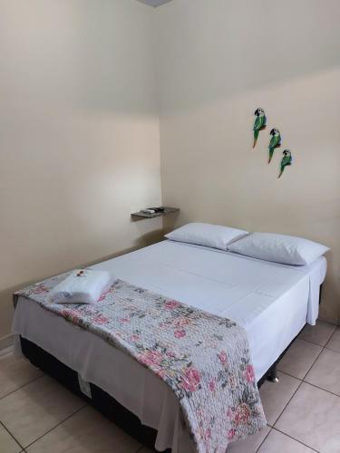um quarto com uma cama com um cobertor em Pousada do Professor em Pirenópolis