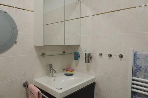 Un baño blanco con lavabo y espejo. en Petit Paradis a Saint Mandrier 1 chambre plage à 4 mn CLIM Parking Wifi, en Saint-Mandrier-sur-Mer