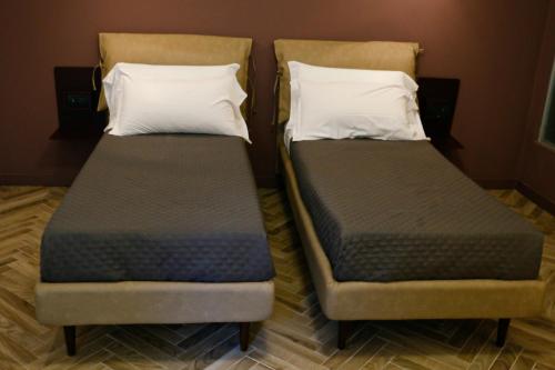 two beds sitting next to each other in a room at Florea Palace in Rome