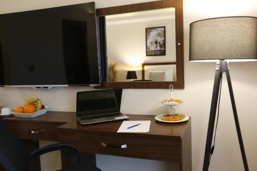a desk in a hotel room with a laptop and a mirror at Cebeci Grand Hotel in Trabzon