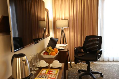 a hotel room with a desk and a chair in a room at Cebeci Grand Hotel in Trabzon