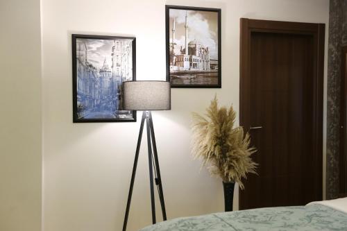 a room with a lamp and pictures on the wall at Cebeci Grand Hotel in Trabzon