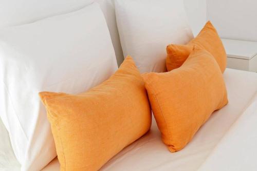 - 2 oreillers orange installés au-dessus du lit dans l'établissement Artury Porto, à Porto
